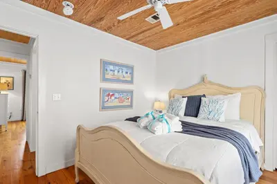 a bedroom with a bed with blue and white pillows at Cute Beach Cottage Steps to the Beach! Panama City Beach, FL! in Panama City Beach
