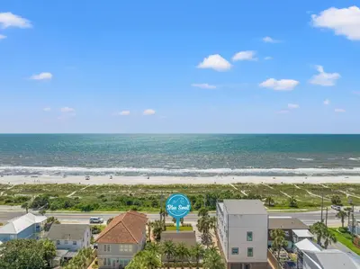 a view of the beach from the balcony of a resort at Cute Beach Cottage Steps to the Beach! Panama City Beach, FL! in Panama City Beach