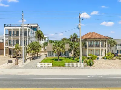 a street with houses and palm trees on a street at Cute Beach Cottage Steps to the Beach! Panama City Beach, FL! in Panama City Beach