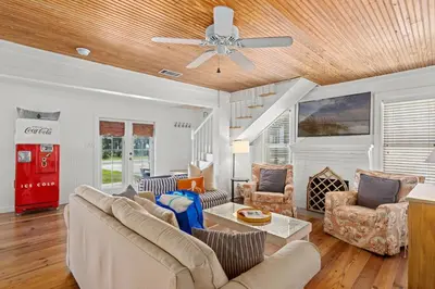 a living room with couches and a ceiling fan at Cute Beach Cottage Steps to the Beach! Panama City Beach, FL! in Panama City Beach