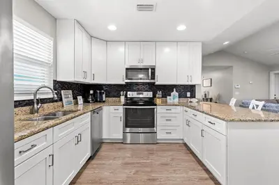 a kitchen with white cabinets and stainless steel appliances at 3BD, 2BA Home! Family Friendly! Close to Beach! HOT TUB! in Panama City Beach