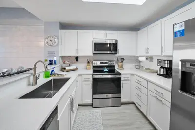a kitchen with white cabinets and a stove top oven at Calypso 3 Luxury Beach Vacation Sleeps 6 in Panama City Beach