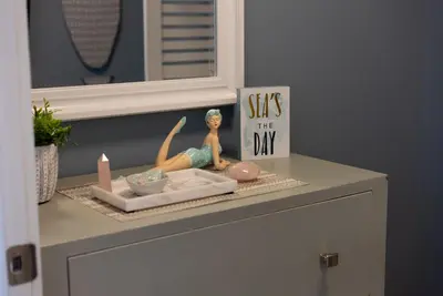 a shelf with a doll and a sign on a dresser at Calypso 3 Luxury Beach Vacation Sleeps 6 in Panama City Beach