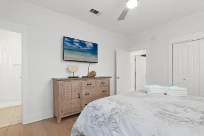 a white bedroom with a bed and a wooden dresser at Book This Top Rated Luxury Home in Seagrove Now! Private Pool! in Santa Rosa Beach