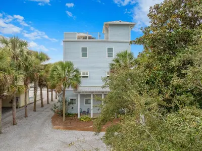 a white house with palm trees in front of it at Book This Top Rated Luxury Home in Seagrove Now! Private Pool! in Santa Rosa Beach