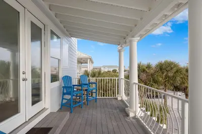 a porch with two blue chairs and a table at Book This Top Rated Luxury Home in Seagrove Now! Private Pool! in Santa Rosa Beach