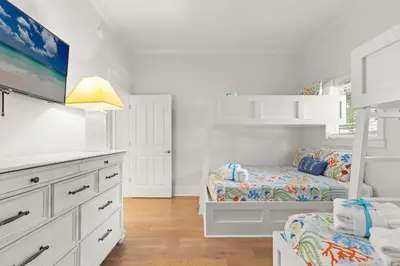 a white bedroom with two beds and a tv at Book This Top Rated Luxury Home in Seagrove Now! Private Pool! in Santa Rosa Beach