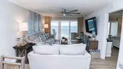 a living room with a white couch and a television at 5-STAR Beachfront - 2br & 2ba Total Remodel - Dunes of Panama D1105 in Panama City Beach