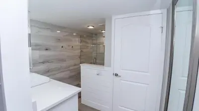 a white bathroom with a shower and a white door at 5-STAR Beachfront - 2br & 2ba Total Remodel - Dunes of Panama D1105 in Panama City Beach
