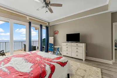 a bedroom with a bed and a tv and windows at The Lost Flip Flop at Laketown Wharf #2012 by Nautical Properties in Panama City Beach