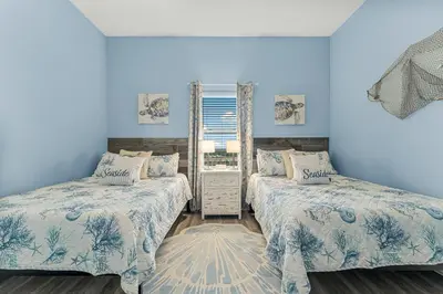 two beds in a room with blue walls at The Lost Flip Flop at Laketown Wharf #2012 by Nautical Properties in Panama City Beach