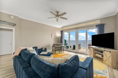 a living room with a blue couch and a flat screen tv at The Lost Flip Flop at Laketown Wharf #2012 by Nautical Properties in Panama City Beach