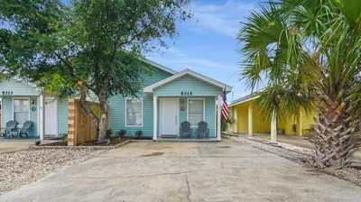 a blue and yellow house with a palm tree at Red Neptune by Nautical Properties in Panama City Beach