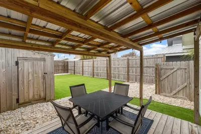 a patio with a table and chairs under a pergola at Red Neptune by Nautical Properties in Panama City Beach