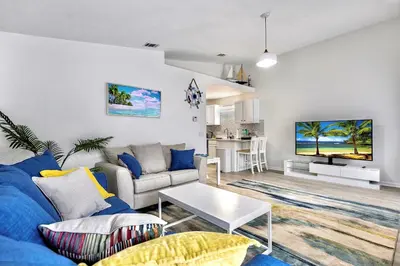 a living room with a blue couch and a tv at Lagoon 2621 by Nautical Properties in Panama City Beach
