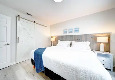 a bedroom with a white bed with a wooden headboard at Lagoon 2621 by Nautical Properties in Panama City Beach
