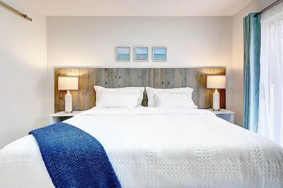 a bedroom with a large white bed with two lamps at Lagoon 2621 by Nautical Properties in Panama City Beach
