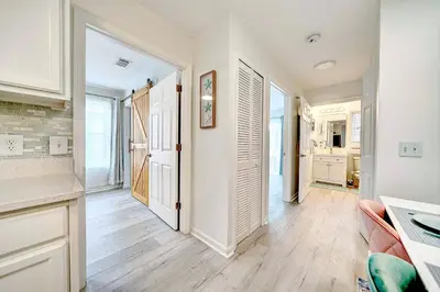 a kitchen with white cabinets and a hard wood floor at Lagoon 2621 by Nautical Properties in Panama City Beach