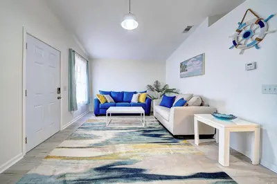 a living room with a blue couch and a table at Lagoon 2621 by Nautical Properties in Panama City Beach