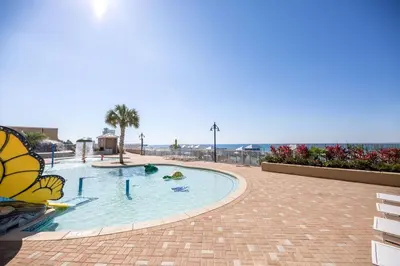 a large swimming pool with the ocean in the background at Some Beach Some Where at Laketown Wharf #825 by Nautical Properties in Panama City Beach