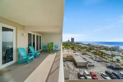 a balcony with blue chairs and a view of the ocean at Beachy King at Laketown Wharf #812 by Nautical Properties in Panama City Beach