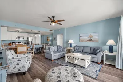 a living room with a couch and a table at Beachy King at Laketown Wharf #812 by Nautical Properties in Panama City Beach