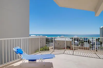 a blue chair on a balcony with the ocean at Bikini Bottom at Laketown Wharf #501 by Nautical Properties in Panama City Beach