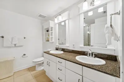 a white bathroom with two sinks and a toilet at Grand Panama #2-1307 in Panama City Beach