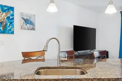 a kitchen counter with a sink and a tv at Grand Panama #2-1307 in Panama City Beach
