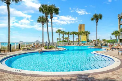 a swimming pool at a resort with palm trees at Grand Panama #2-1307 in Panama City Beach