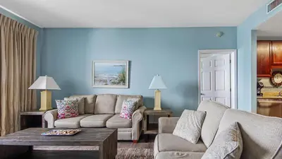 a living room with a couch and a table at Sunsational at Laketown Wharf #1924 by Nautical Properties in Panama City Beach