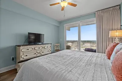 a bedroom with a bed with a television and a window at Deja Blue at Laketown Wharf #1831 by Nautical Properties in Panama City Beach