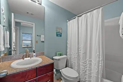 a bathroom with a sink and a toilet and a shower at Deja Blue at Laketown Wharf #1831 by Nautical Properties in Panama City Beach