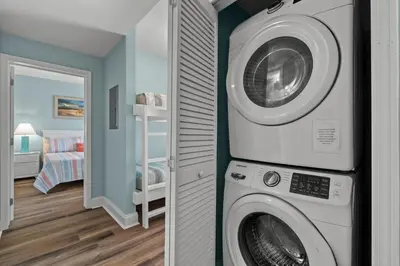 a washer and dryer in a room with a bedroom at Deja Blue at Laketown Wharf #1831 by Nautical Properties in Panama City Beach
