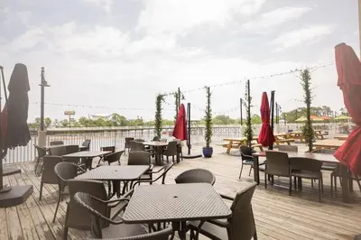 a patio with tables and chairs on a deck at Deja Blue at Laketown Wharf #1831 by Nautical Properties in Panama City Beach