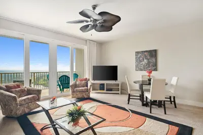 a living room with a dining table and a television at Laketown Wharf #1737 by Nautical Properties in Panama City Beach