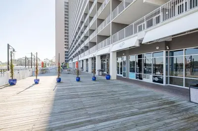 an empty building with blue potted plants on a boardwalk at Sea-Renity at Laketown Wharf #1607 by Nautical Properties in Panama City Beach