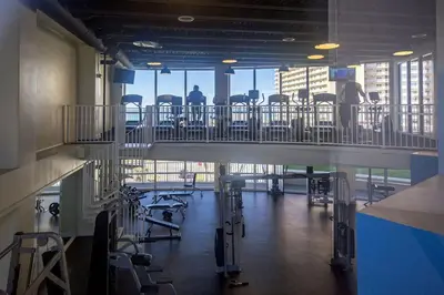 a gym with chairs and tables in a building at Sea-Renity at Laketown Wharf #1607 by Nautical Properties in Panama City Beach