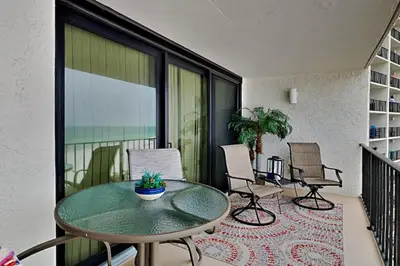 a patio with a table and chairs on a balcony at Edgewater Tower Iii 612 in Panama City Beach