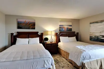 two beds in a hotel room with white sheets at Edgewater Tower Iii 612 in Panama City Beach