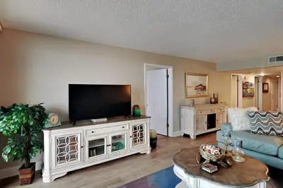 a living room with a flat screen tv on a entertainment center at Edgewater Tower Iii 612 in Panama City Beach