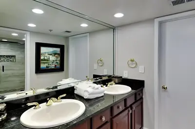 a bathroom with two sinks and a large mirror at Edgewater Tower Iii 612 in Panama City Beach
