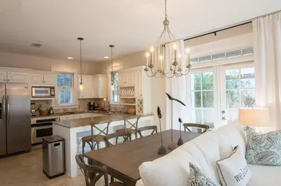 a kitchen and living room with a table and a couch at Beach Music in Rosemary Beach