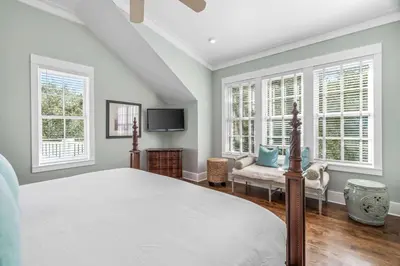a bedroom with a bed and a tv and windows at Flagship of Watersound in Watersound Beach