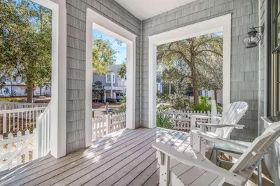 a porch with white rocking chairs and windows at Flagship of Watersound in Watersound Beach