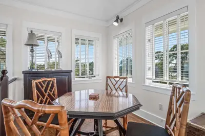 a dining room with a table and chairs and windows at Flagship of Watersound in Watersound Beach