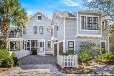 a white house with a palm tree at Flagship of Watersound in Watersound Beach