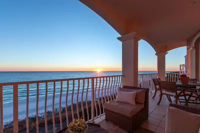 a porch with a view of the ocean at sunset at Front Row in Inlet Beach