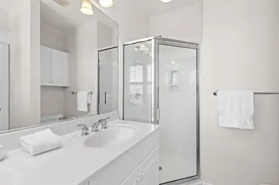a white bathroom with a sink and a shower at Front Row in Inlet Beach