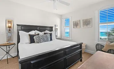a bedroom with a large bed and two windows at Front Row in Inlet Beach
